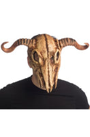 A person wearing a realistic animal skull mask with curved horns, photographed against a plain white background.