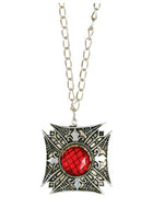 A gothic-style pendant necklace featuring a silver-toned ornate cross-shaped pendant with a central red faceted gemstone, suspended from a silver link chain against a plain white background.