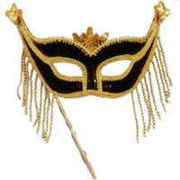 Black and gold masquerade mask with gold sequins, bead trim, fringe, star tips, and a decorative stick, shown on a plain white background.