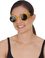 A woman wearing round steampunk-style sunglasses with gold frames, black lenses, and decorative gold studs on the side, shown against a plain white background.