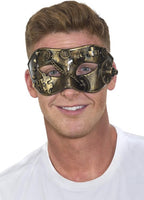 A man wearing a steampunk-style masquerade mask with gold and bronze metallic gears, cogs, and puzzle-piece details, photographed against a plain white background.