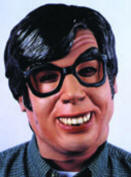 A close-up portrait of a man mask with black hair, thick black glasses, and a wide smile, wearing a dark patterned shirt against a light blue background.