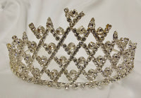 A silver tiara crown embellished with clear rhinestones and crystals, displayed on a soft white fabric background.