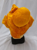 A bright orange plush or faux-fur costume headpiece displayed on a black stand against a white fabric backdrop.
