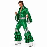 A man modeling a shiny green 1960s-style Elvis-style costume jumpsuit with silver embellishments, silver bell sleeves, and silver tiered flares, paired with white cowboy boots, on a white studio background.