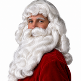 A man dressed as Santa Claus, wearing a red velvet suit with white faux fur trim, a deluxe Santa Claus Wig and Beard Set with and attached Moustache posed against a solid white background.